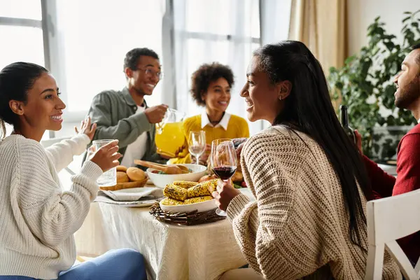 A group of friends share laughter and delicious food during a Thanksgiving gathering at home. — Stock Photo