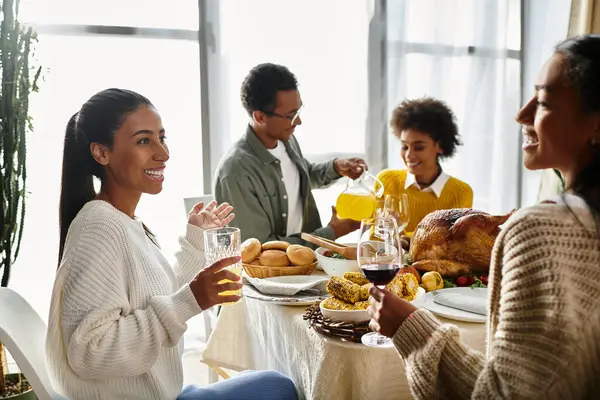 Friends share laughter and delicious food during a warm Thanksgiving celebration at home. — Stock Photo
