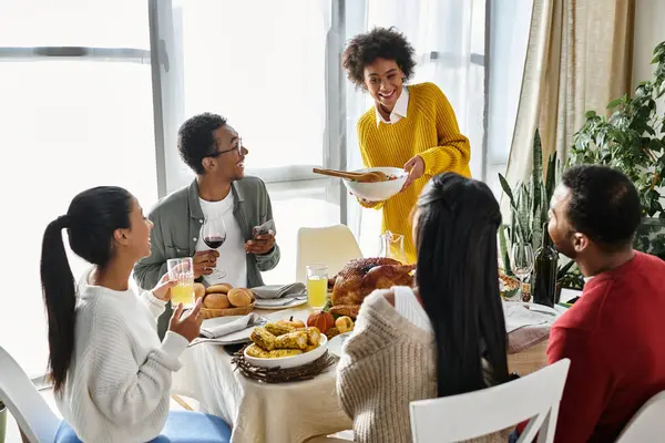 A cheerful gathering of friends enjoying a Thanksgiving meal with laughter and delightful dishes. — Stock Photo