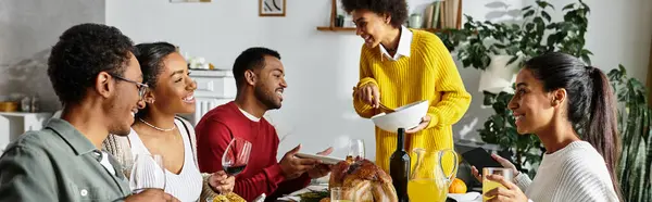 A joyful gathering of friends celebrating Thanksgiving with a festive meal and warm smiles. — Stock Photo