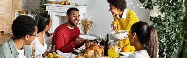 A group of friends share laughter and a festive meal during their Thanksgiving celebration at home. — Stock Photo