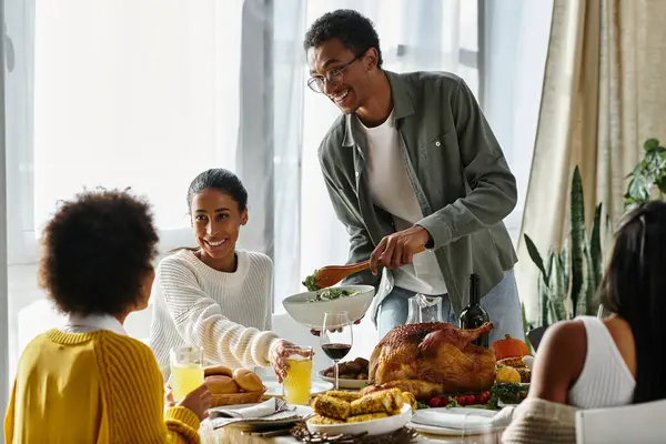 Un gruppo di amici si riunisce a casa, condividendo risate e cibo delizioso durante il Ringraziamento. — Foto stock