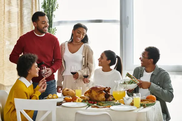 A group of friends enjoy a festive Thanksgiving meal, sharing stories and toasting together. — Stock Photo