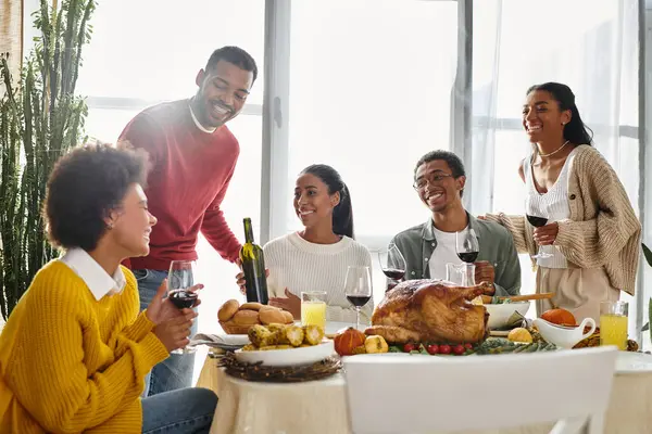 A group of friends enjoys a festive Thanksgiving meal, bonding over food and drinks. — Stock Photo