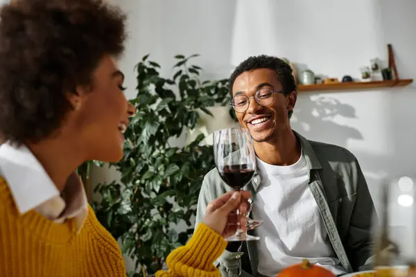 Un gruppo di amici che condividono un delizioso pasto del Ringraziamento pieno di risate e gioia. — Foto stock