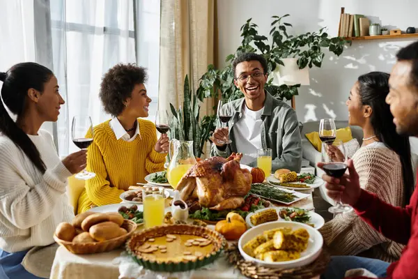 A group of friends enjoy a festive Thanksgiving meal filled with laughter, food, and drinks. — Stock Photo