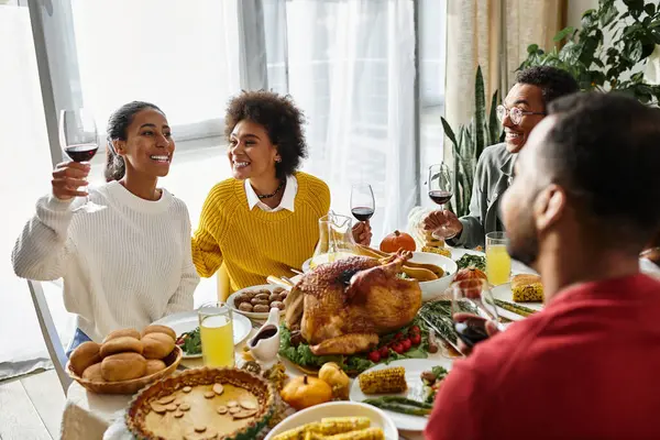 Friends gather, laughing around a beautifully set table, toasting and sharing a festive meal. — Stock Photo