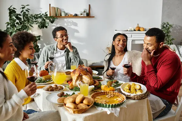 Un gruppo allegro si gode la cena del Ringraziamento, condividendo risate, storie e piatti gustosi.. — Foto stock