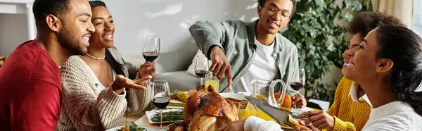 A warm gathering of friends enjoying Thanksgiving dinner, sharing laughter and food. — Stock Photo