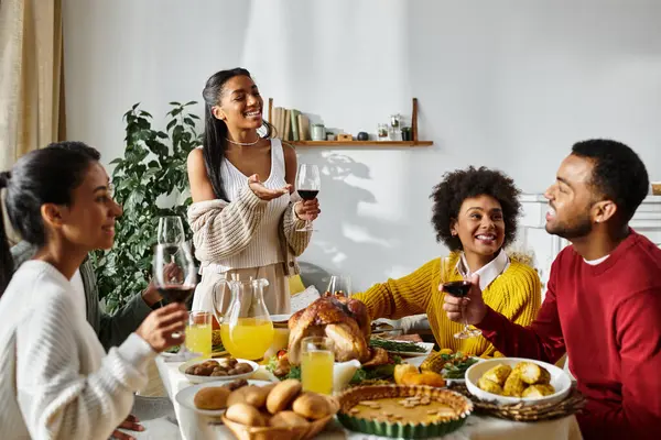 A group of friends gathers around the table, sharing a festive Thanksgiving meal filled with joy. — Stock Photo