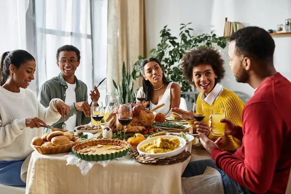 Un allegro gruppo di amici si gode una festa del Ringraziamento insieme, condividendo storie e cibo. — Foto stock