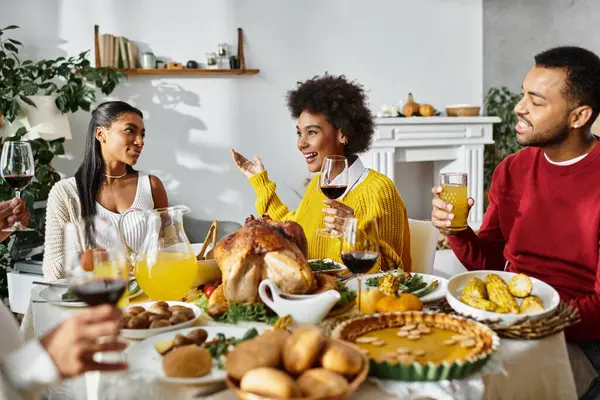 A group of friends enjoys a lively Thanksgiving celebration around a beautifully set table. — Stock Photo