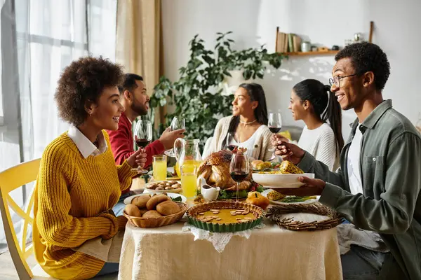Un gruppo di amici gusta deliziosi piatti mentre celebra il Ringraziamento in un ambiente caldo. — Foto stock
