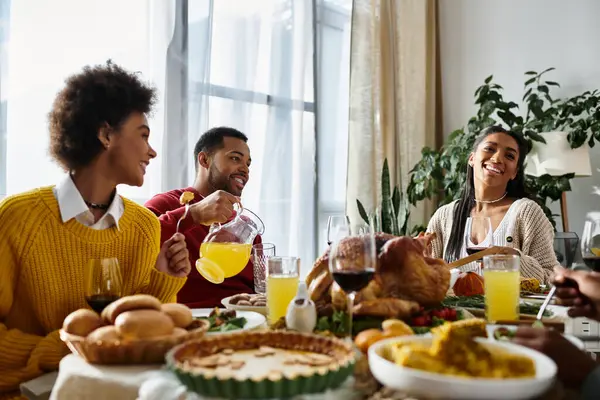 A group of friends shares a warm Thanksgiving dinner, enjoying good food and each others company — Stock Photo
