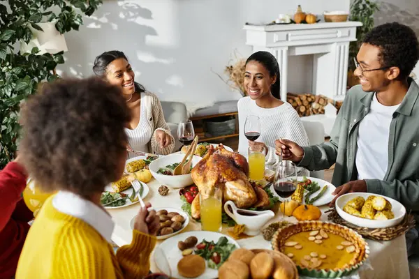 Un gruppo di amici si gode una cena festiva del Ringraziamento piena di risate e cibo delizioso. — Foto stock