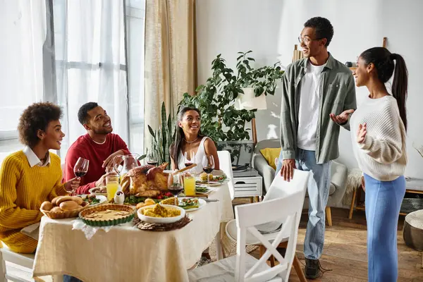 A group of friends enjoys Thanksgiving together, sharing stories and savoring a feast. — Stock Photo