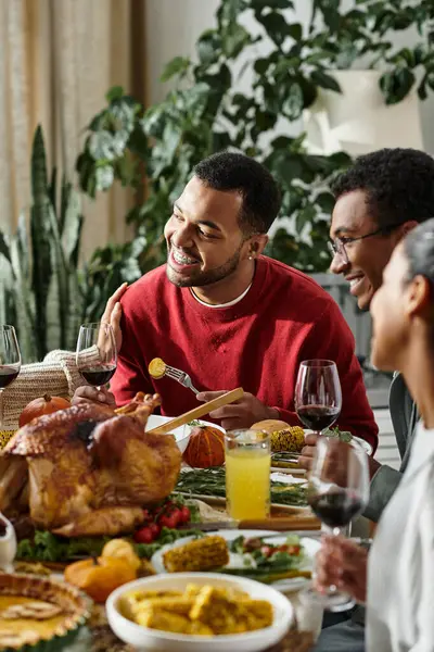 A group of friends joyfully shares a Thanksgiving meal filled with laughter, food, and warmth. — Stock Photo