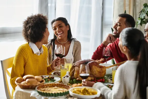 A warm group of friends share laughter and delicious food during their Thanksgiving gathering. — Stock Photo