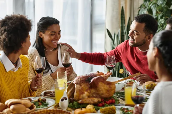 A group of friends gathers around a beautifully arranged table, enjoying Thanksgiving festivities. — Stock Photo