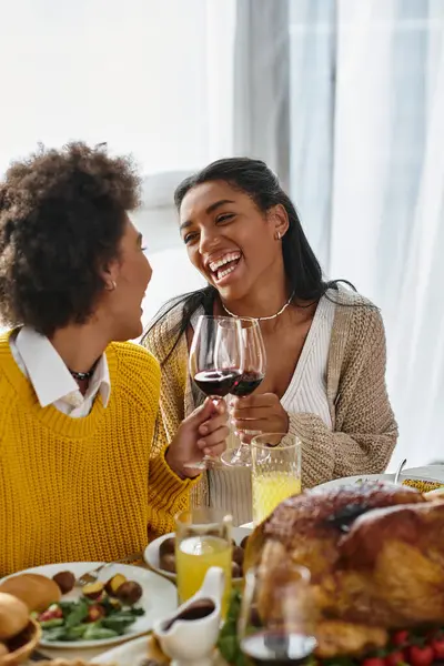 Gli amici si riuniscono attorno a un tavolo ben organizzato, condividendo risate e cibo delizioso insieme.. — Foto stock