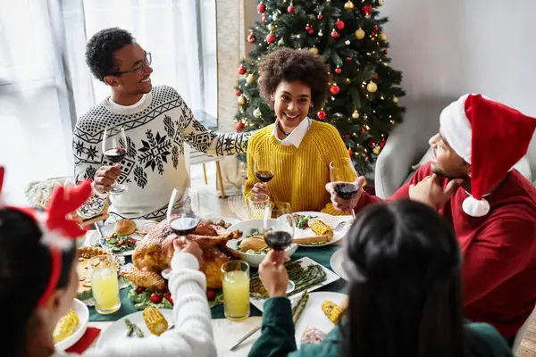 A festive gathering of friends sharing delicious food, drinks, and holiday joy in a cozy home. — Stock Photo