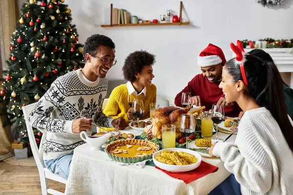 Un gioioso gruppo di amici che si legano per una deliziosa festa di Natale a casa. — Foto stock