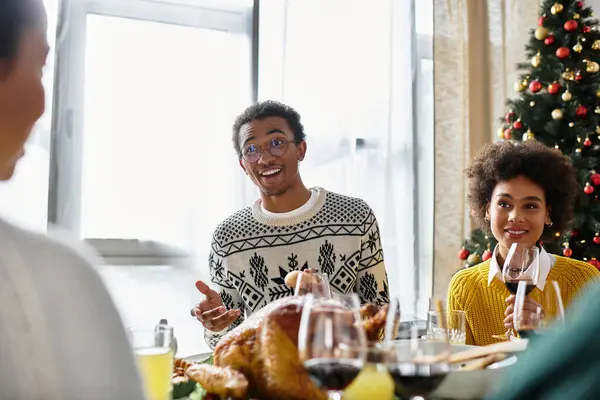 A festive gathering of friends sharing laughs, food, and drinks during Christmas celebrations. — Stock Photo