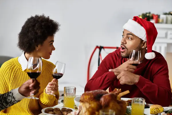 A cheerful gathering of friends sharing laughter and drinks while celebrating Christmas together. — Stock Photo
