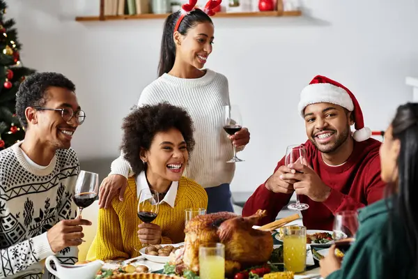Ein fröhliches Treffen von Freunden, die Weihnachten mit Lachen, Getränken und einem köstlichen Festmahl feiern. — Stockfoto