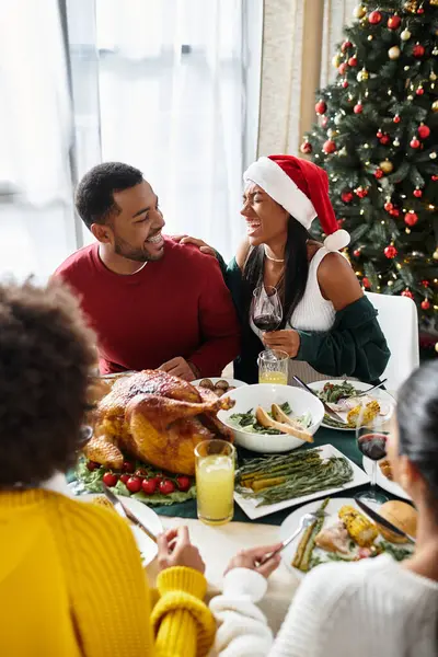 A joyful gathering of friends enjoying a festive Christmas dinner together at home. — Stock Photo