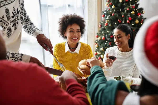 Friends share joy during a cozy Christmas celebration, enjoying food and laughter together. — Stock Photo