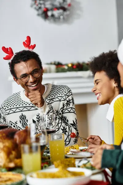 Un joyeux rassemblement d'amis profitant d'un repas de Noël festif et partageant des moments joyeux. — Photo de stock