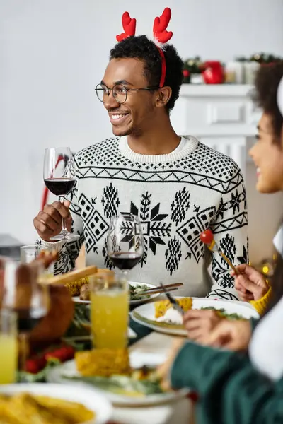 Friends gather around a table, celebrating Christmas with food and drinks. — Stock Photo