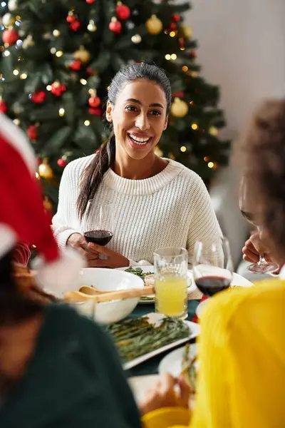 Friends gather at a festive table, sharing laughter and tasty food for Christmas. — Stock Photo