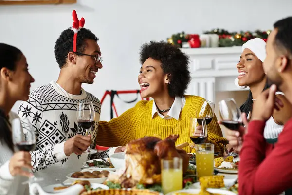 A group of friends share laughter and drinks while celebrating Christmas at home. — Stock Photo