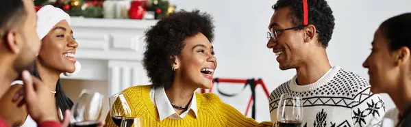 A group of friends gathers at home, sharing laughter and enjoying a festive Christmas celebration. — Stock Photo