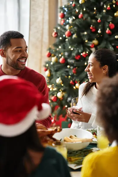 Friends gather around a beautifully set table, enjoying Christmas dinner and sharing joyful moments. — Stock Photo