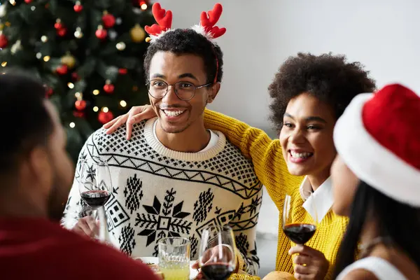 Un gruppo di amici condivide risate e allegria festiva mentre si beve a casa durante il Natale. — Foto stock