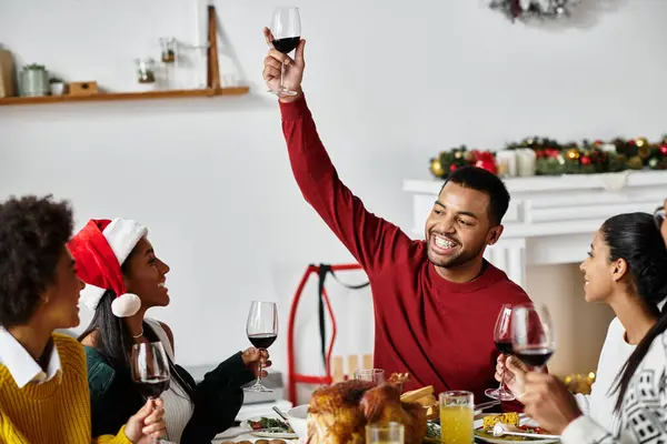 A group of friends raise glasses in a cheerful toast during their Christmas celebration. — Stock Photo