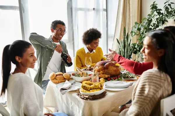 Un caldo raduno di amici che si godono la cena del Ringraziamento piena di risate e buon cibo. — Foto stock