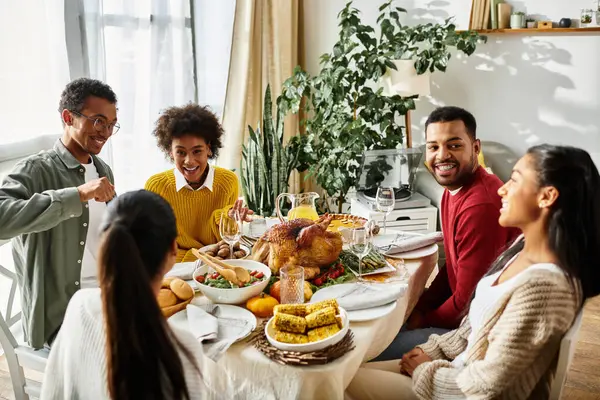 A cheerful group of friends enjoy a delicious Thanksgiving feast together at home. — Stock Photo