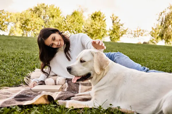 A joyful young woman relaxes outdoors, bonding with her dog on a warm autumn afternoon. — Stock Photo