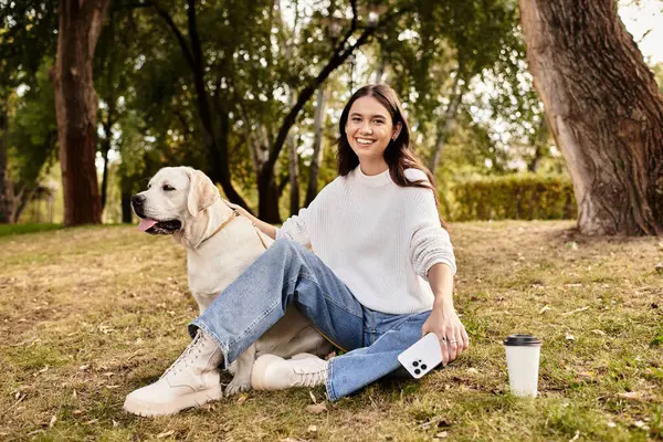 Embracing autumns beauty, a youthful woman relaxes in the park with her dog, savoring each moment. — Stock Photo