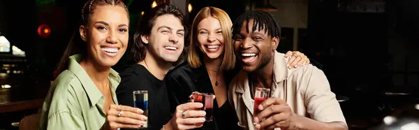 Diverse coworkers enjoy a fun evening together, raising their glasses in celebration at an event. — Stock Photo
