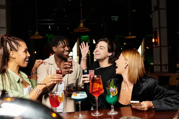 Colleagues joyfully raise colorful cocktails, enjoying the festive atmosphere together. — Stock Photo
