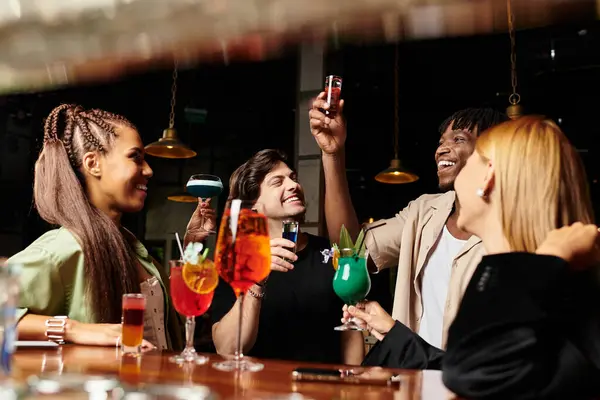 Colleagues share laughter and vibrant cocktails at a festive corporate gathering. — Stock Photo