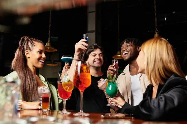 A group of diverse colleagues shares laughter and cocktails at a trendy corporate gathering. — Stock Photo