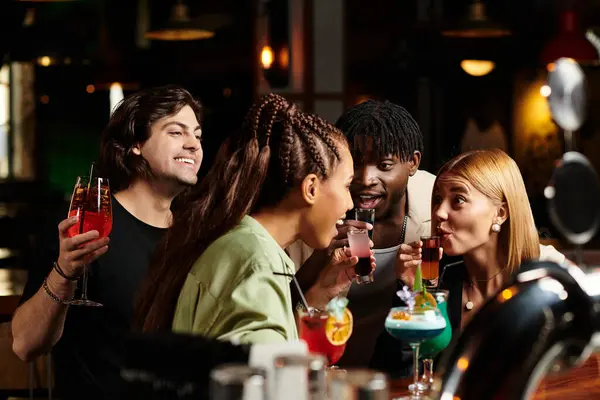 Junge Berufstätige genießen bunte Cocktails, lachen und plaudern miteinander. — Stockfoto