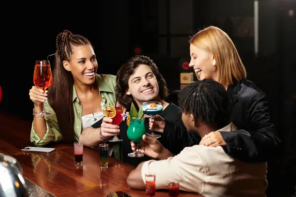 Colleagues enjoy vibrant cocktails and laughter during a festive corporate celebration. — Stock Photo