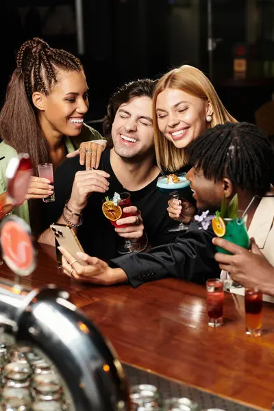 Cuatro colegas comparten momentos alegres y bebidas en una animada fiesta corporativa después del trabajo. — Stock Photo